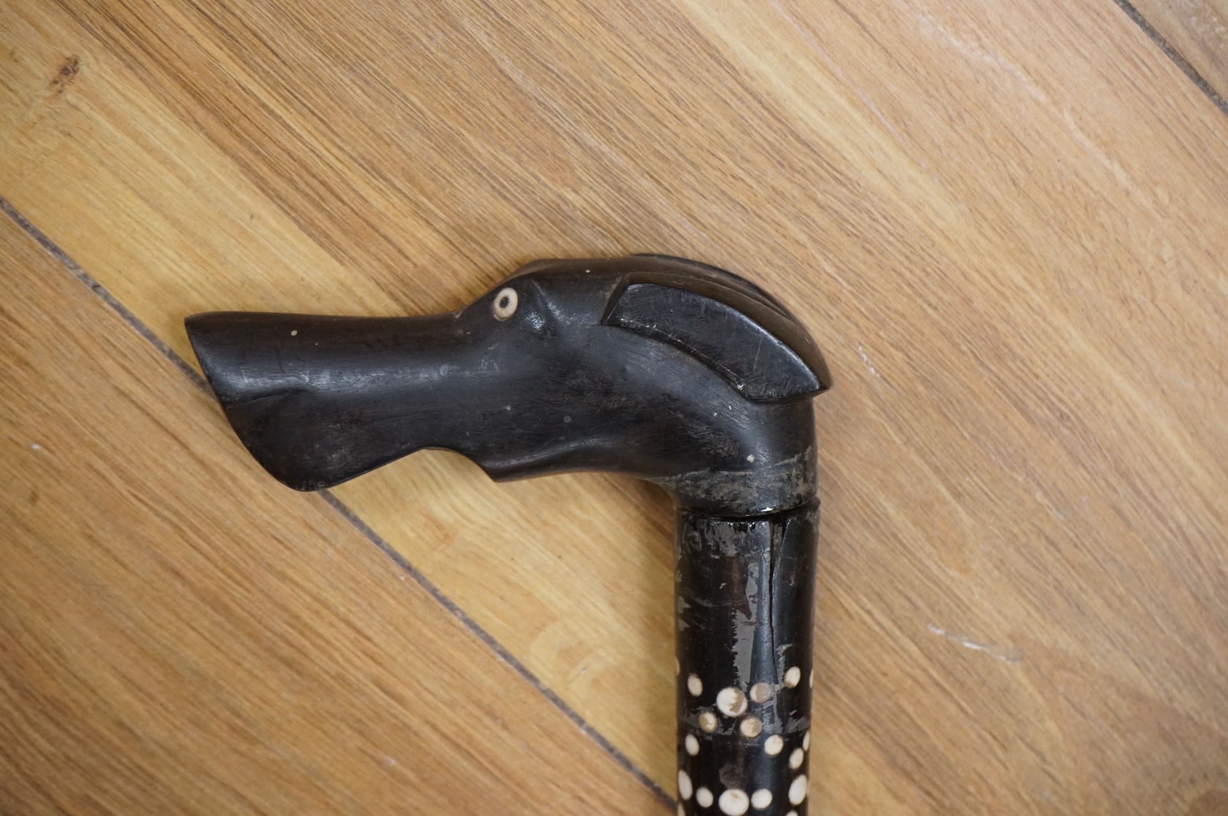 An ebony walking stick with bone inlay, the handle in the form of a dog's head, 88cm in length